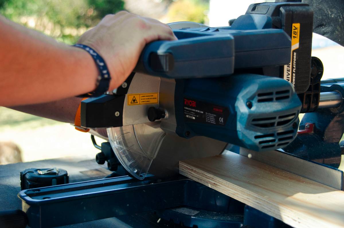 Close-up of a staple gun for woodworking driving staples into birch plywood without splitting the wood